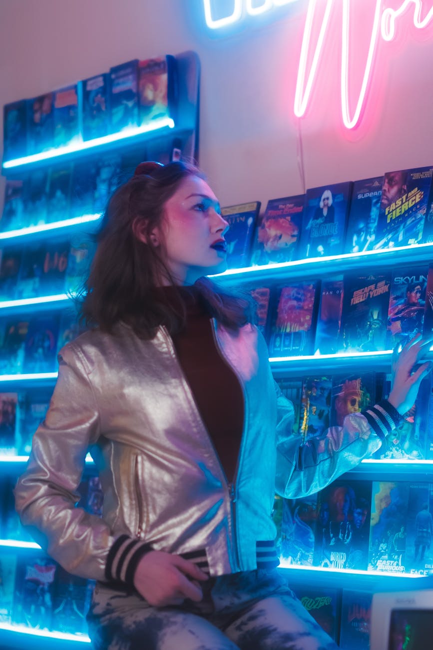 woman in jacket standing near music albums on wall
