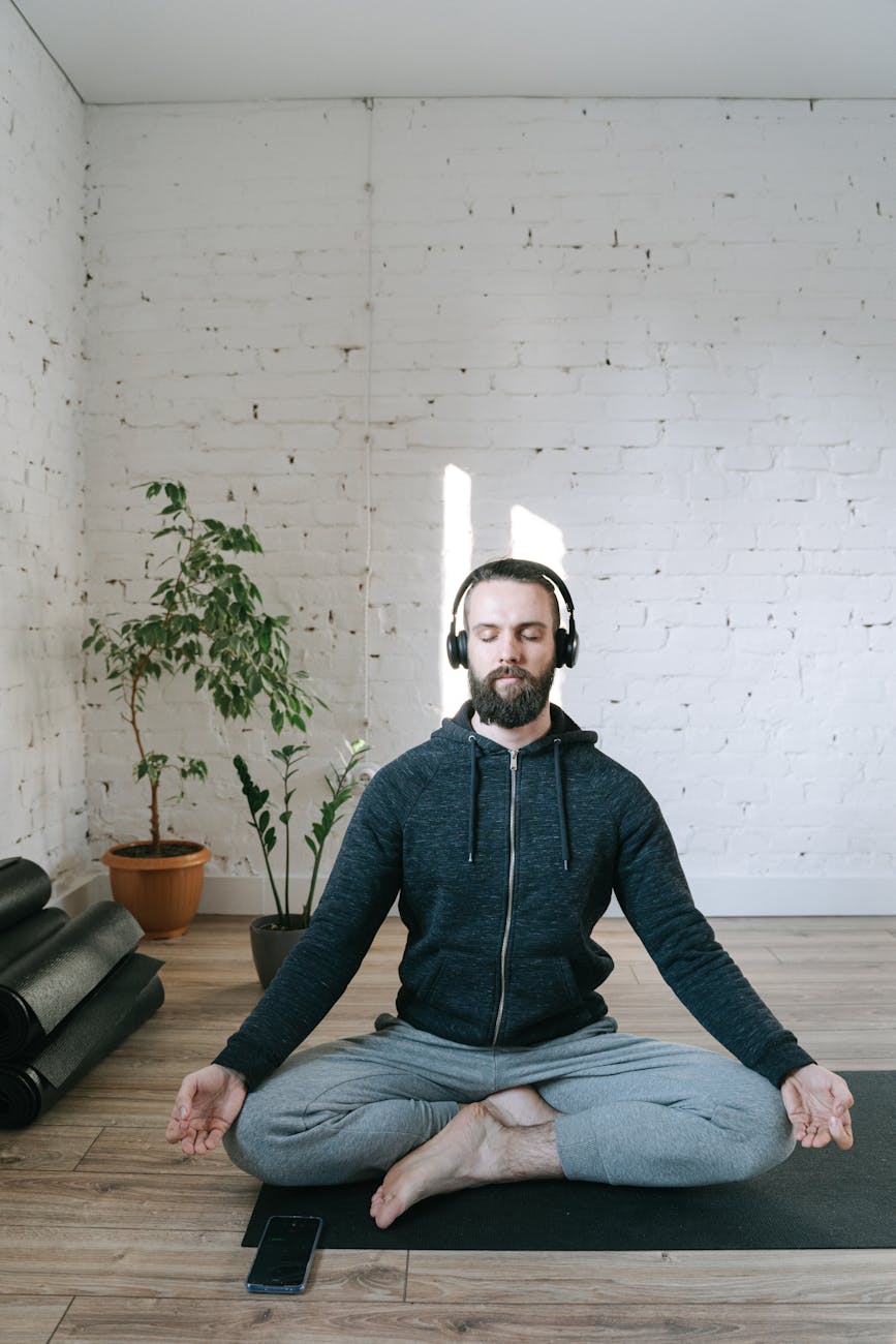 a man listening to music while doing yoga
