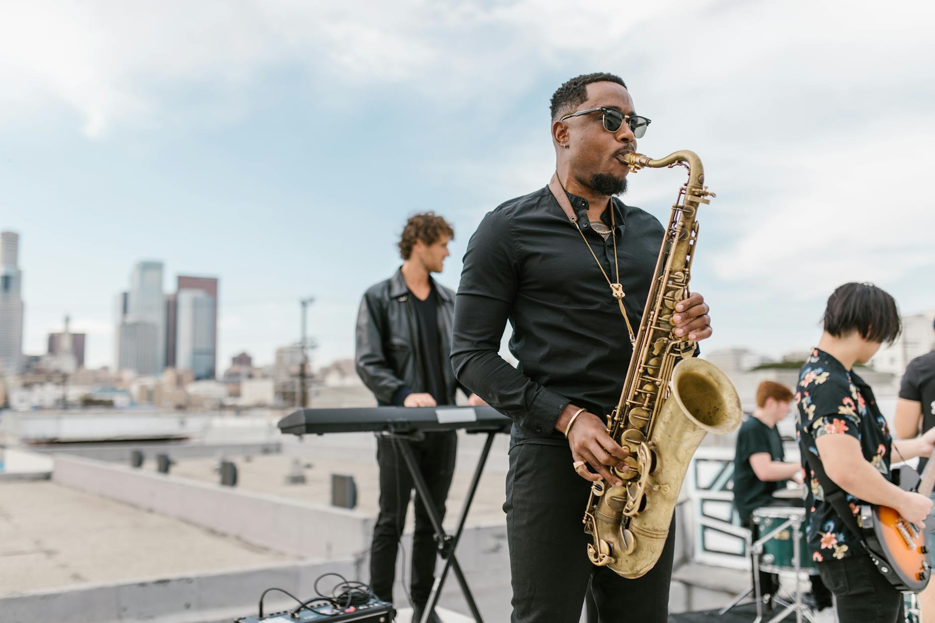 a man in black long sleeves playing saxophone