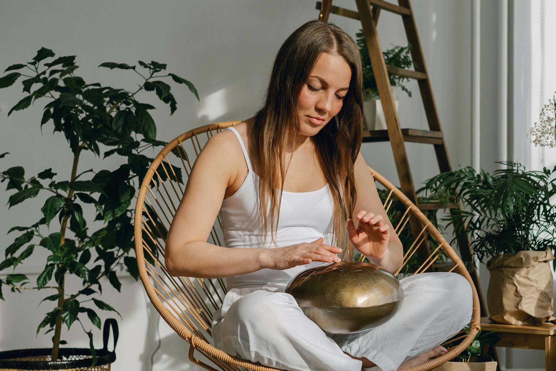 young woman playing on steel tongue drum
